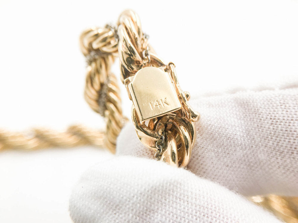 14K stamp on a rope chain's clasp identifies it's pure gold percentage.
