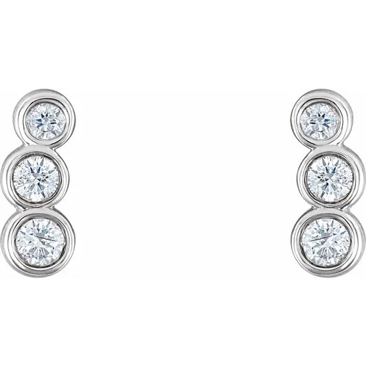 Pair of white gold diamond ear climbers with three stones in a bezel setting