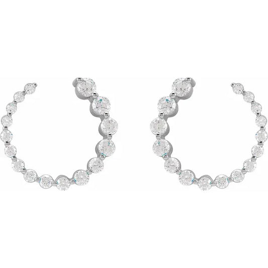 White gold diamond huggie earrings on a white background