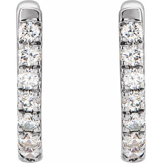 White gold diamond huggie earrings on a white background