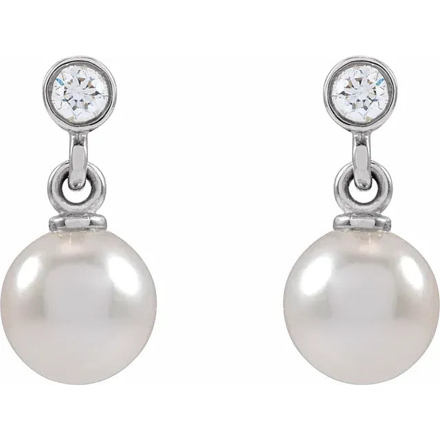 Silver pearl and diamond drop earrings on a white background