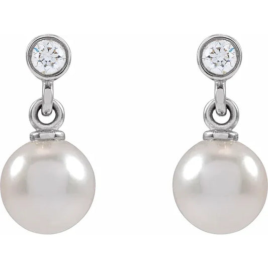 Silver pearl and diamond drop earrings on a white background