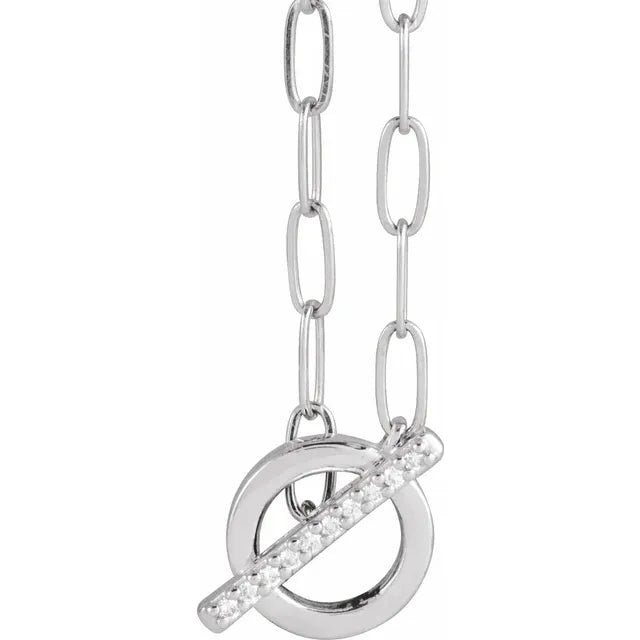 White gold necklace with a circular pendant featuring a diamond-studded bar, on a white background