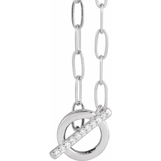 White gold necklace with a circular pendant featuring a diamond-studded bar, on a white background