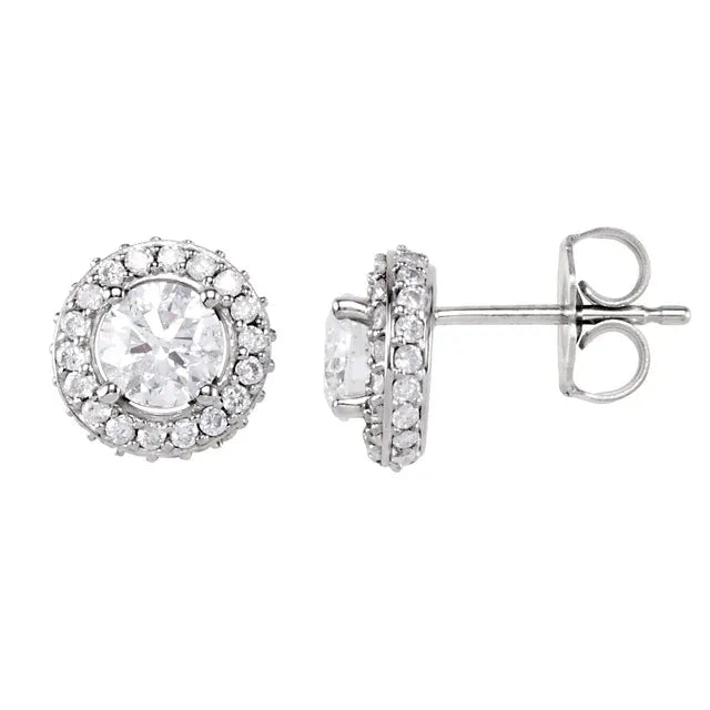 Pair of silver stud earrings, each with a round diamond center surrounded by a halo of smaller diamonds. The background is white.