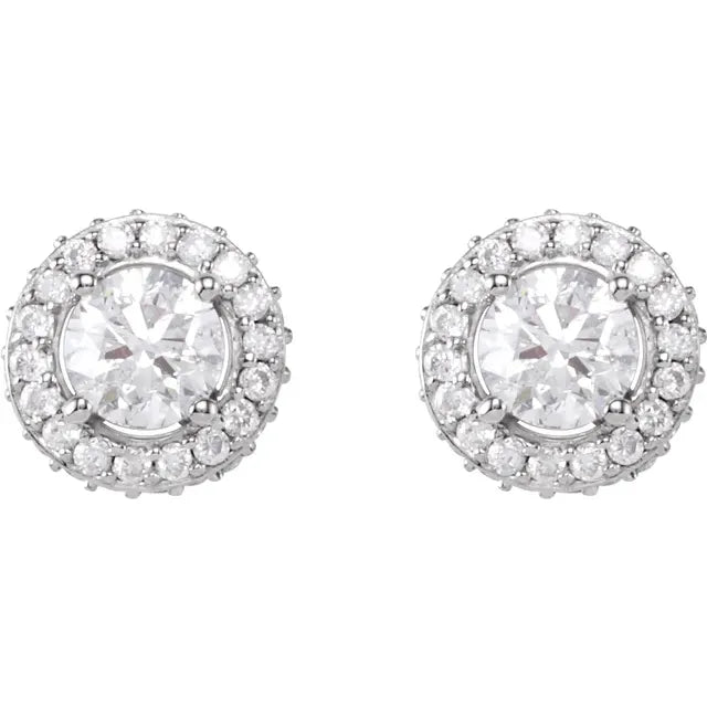 Pair of silver stud earrings, each with a round diamond center surrounded by a halo of smaller diamonds. The background is white.