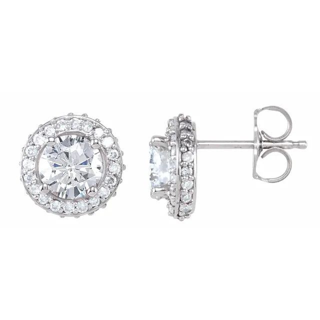 Pair of silver stud earrings, each with a central diamond surrounded by a halo of smaller diamonds. The background is white.