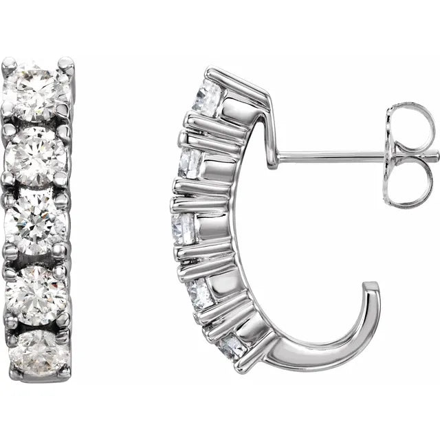 Pair of silver hoop earrings with five diamonds set along the front of each hoop. The background is white.