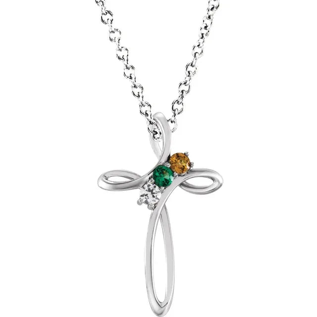 White gold cross necklace with three gemstones on a white background.