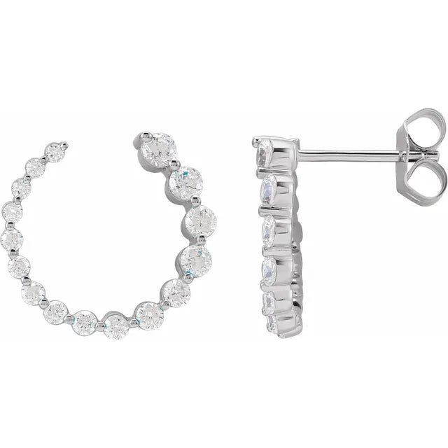 White gold diamond huggie earrings on a white background