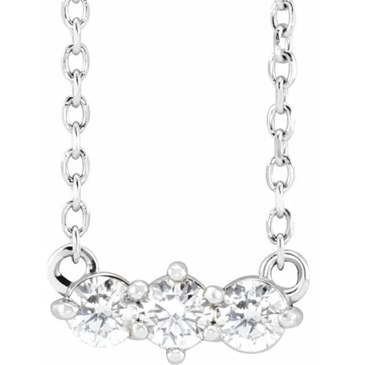 White gold three-stone diamond necklace on a white background.