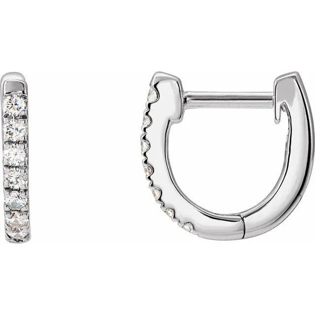 White gold diamond huggie earrings on a white background