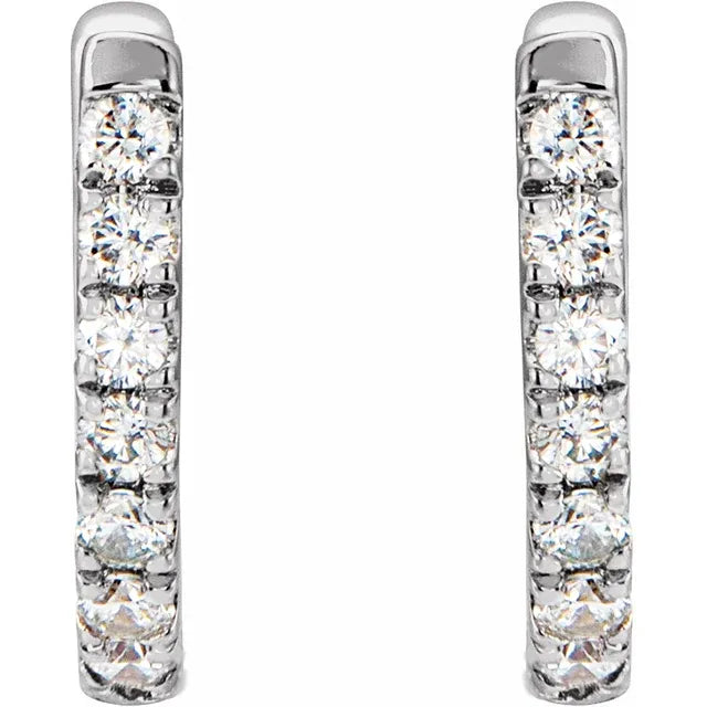 White gold diamond huggie earrings on a white background